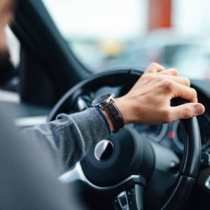 A close up view of an unrecognizable Caucasian male working as a taxi driver.